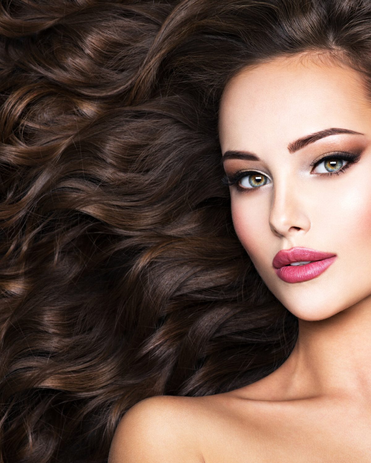 Beautiful woman with long bown hair. Portrait of an sensual adult girl with curly hair.